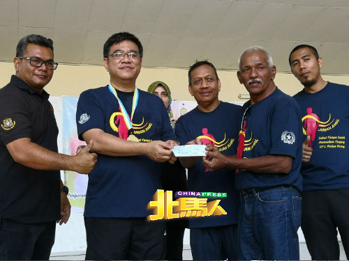 黄汉伟（左2）移交3000令吉给丹绒区马来西亚防止滥用毒品协会，由力哈（左4）代表接领。