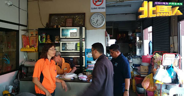 卫生局执法人员突击检查一间食肆，确保业者遵循指南张贴禁烟告示牌。