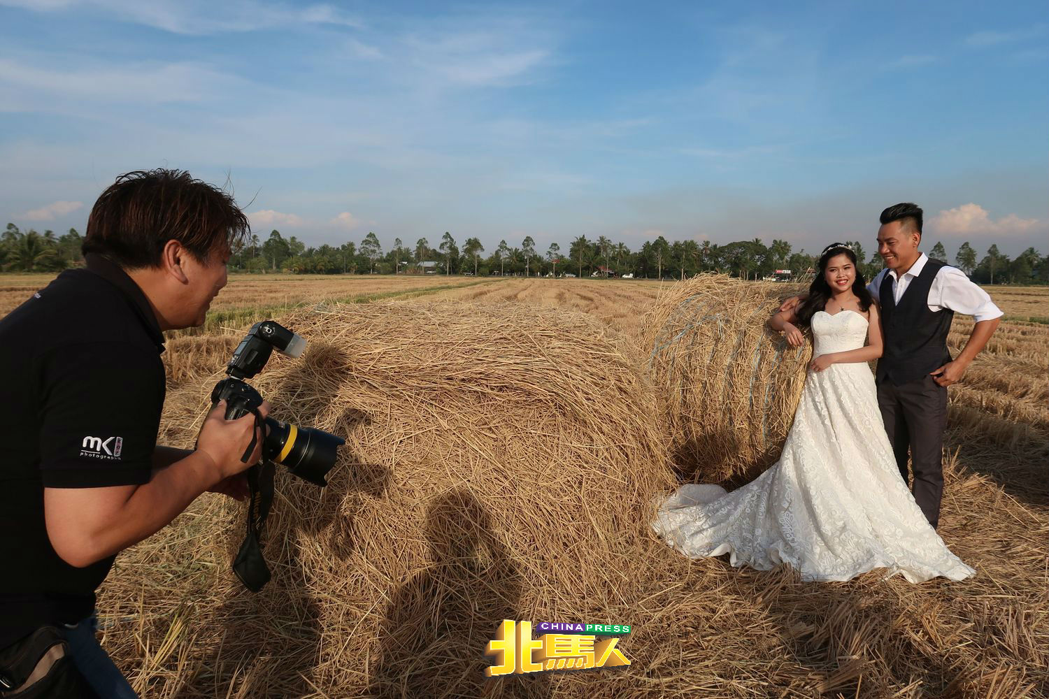张明威（左）和黄煊榕赶上了卷卷草景色，在婚摄的推荐下，在铅县的稻田拍下婚纱照。