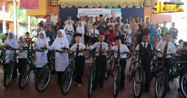 莫哈末都阿（中排左6）代表莫哈末峇迪亚，移交脚车给峇六拜选区内的学生们。