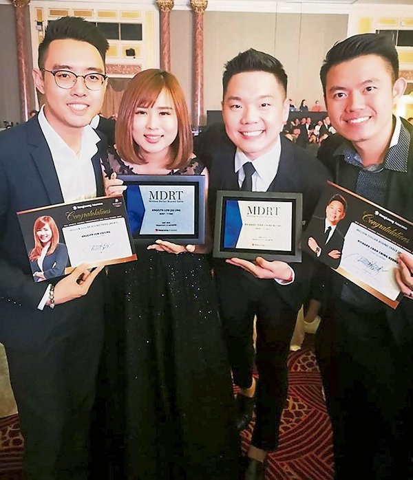 曾进强（左3）与团队成员刘佳伶（左2），一起获得美国百万圆桌会员奖，共创高峰。