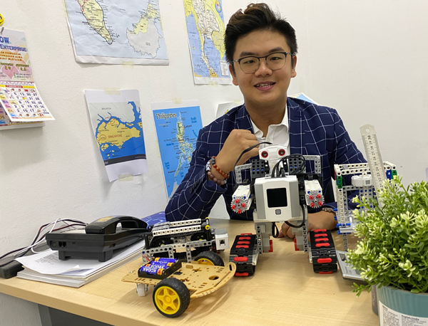 大马KT集团创办人兼执行长郭俊铭展示教育机器人样板。
