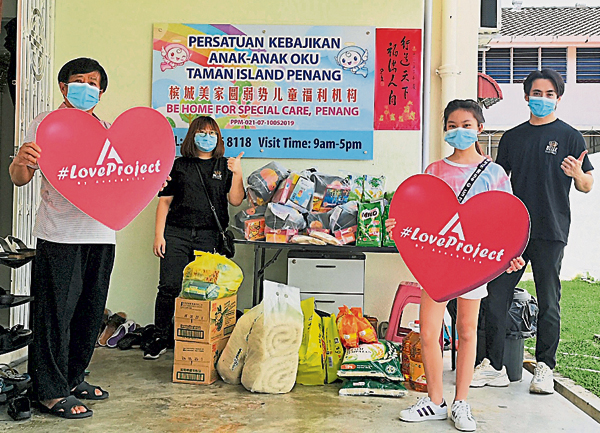 陈芷琳（前右）与她的团队，将物资送到槟城美家圆弱势儿童福利机构。
