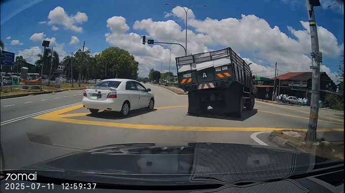 罗厘正准备右转进入右边通道，刚好旁边有一辆白色轿车。（视频截图）