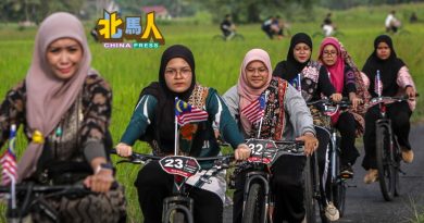 穿传统服骑车  川过田野挥国旗