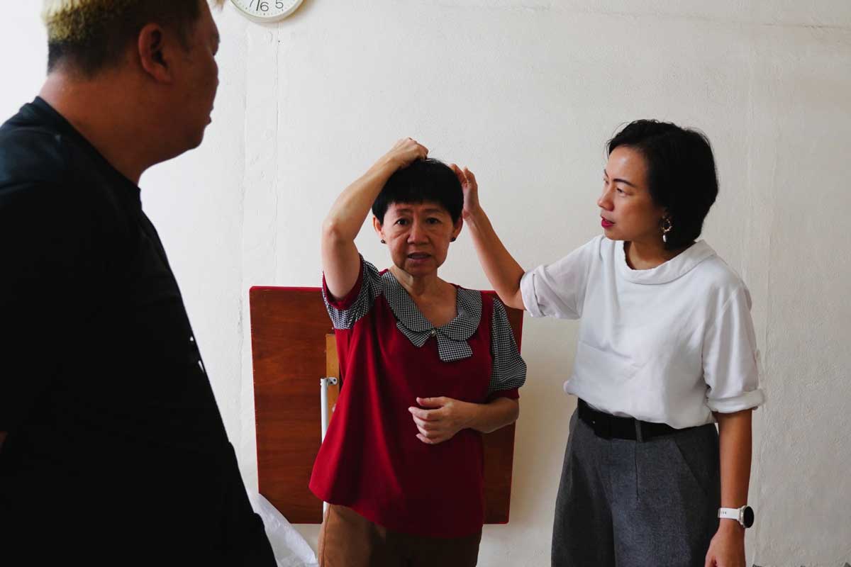 邱嘉丽（左2起）向王丽丽示范，歹徒当时如何粗暴的抓住她的头发，逼她交出财物。